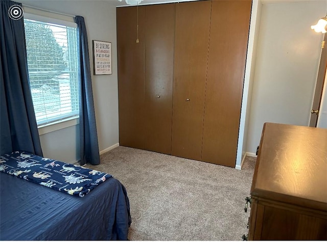 carpeted bedroom featuring multiple windows and a closet