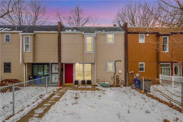 snow covered house with central AC unit