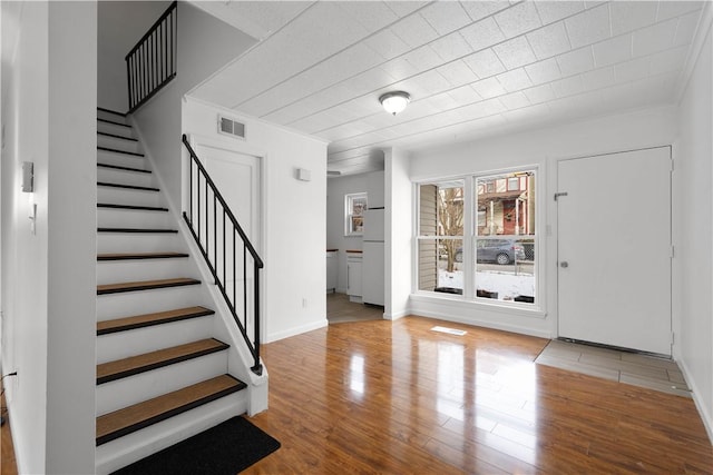 foyer featuring crown molding and wood-type flooring