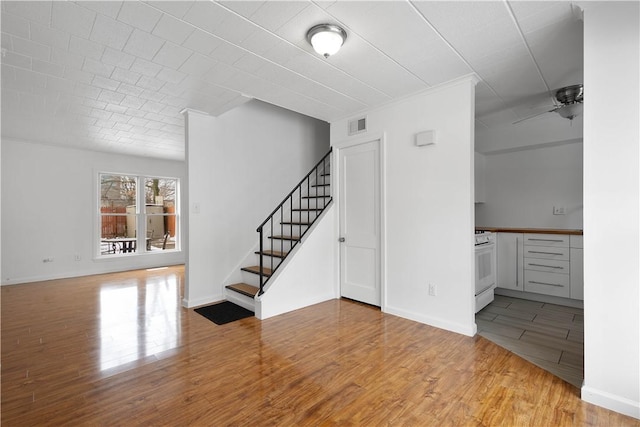 unfurnished living room featuring ceiling fan and light wood-type flooring