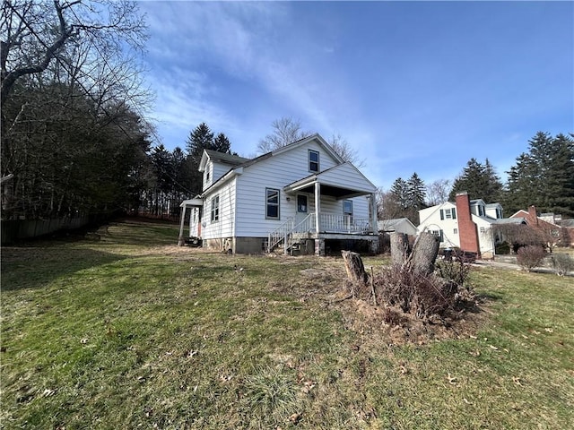 back of house featuring a porch and a lawn