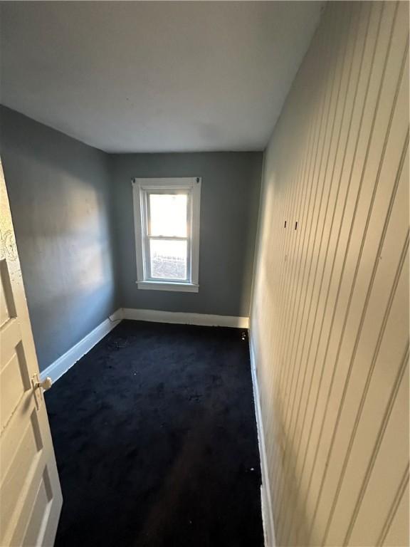 spare room with dark colored carpet