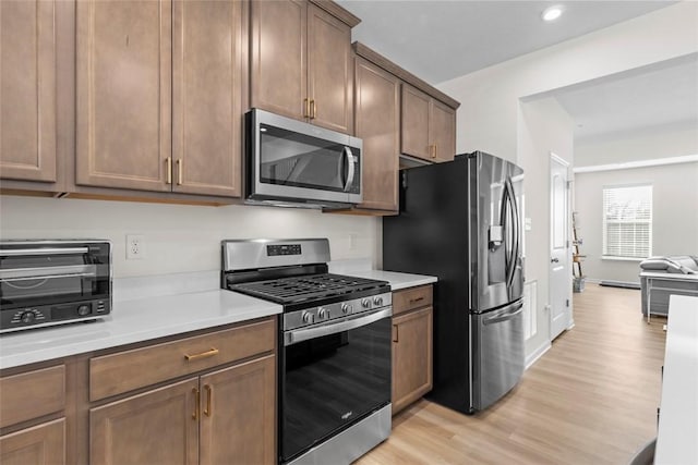 kitchen featuring appliances with stainless steel finishes and light hardwood / wood-style floors