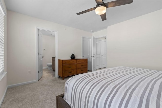 bedroom featuring ceiling fan, ensuite bath, and light carpet