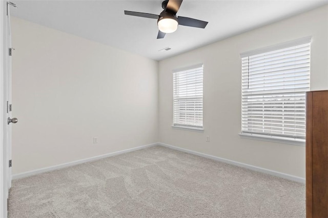 empty room featuring ceiling fan and light carpet