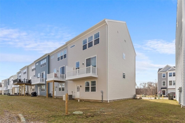 rear view of property with a lawn and central air condition unit