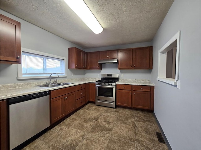 kitchen featuring sink, stainless steel appliances, and a textured ceiling