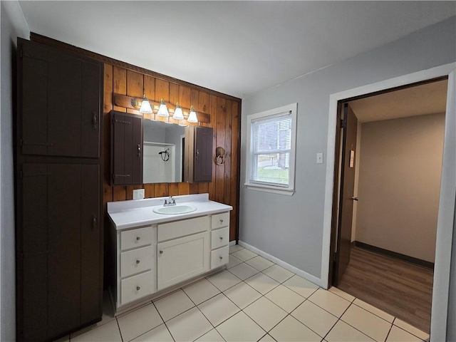 bathroom featuring tile patterned flooring, vanity, and wood walls