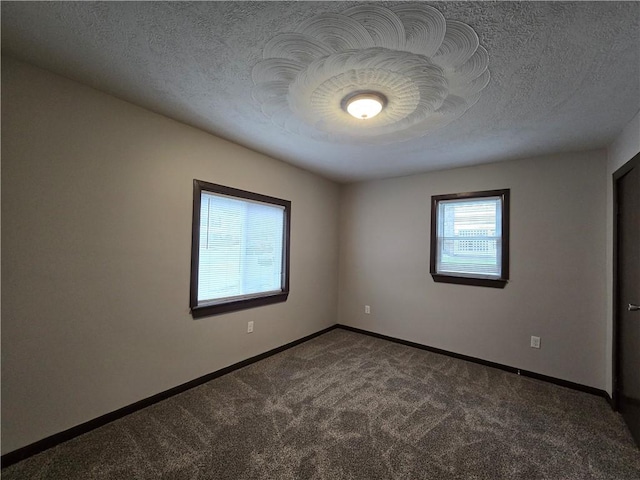 carpeted empty room featuring a textured ceiling