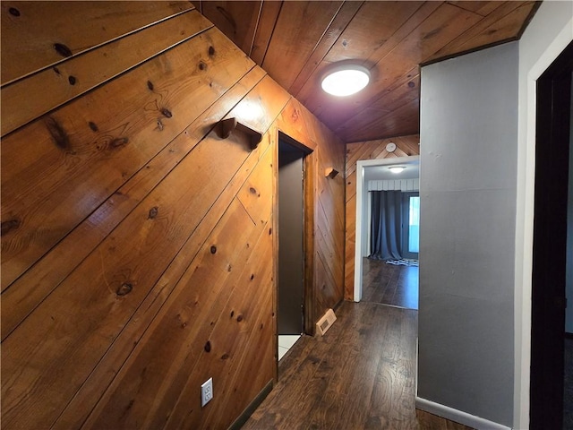 corridor with wood ceiling, wooden walls, and dark hardwood / wood-style floors