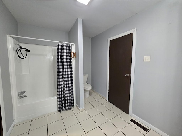 bathroom featuring tile patterned floors, toilet, and shower / bath combo with shower curtain