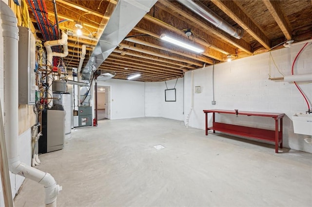 basement featuring water heater, sink, and heating unit