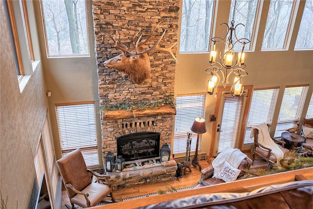 living room featuring an inviting chandelier, a towering ceiling, and a fireplace