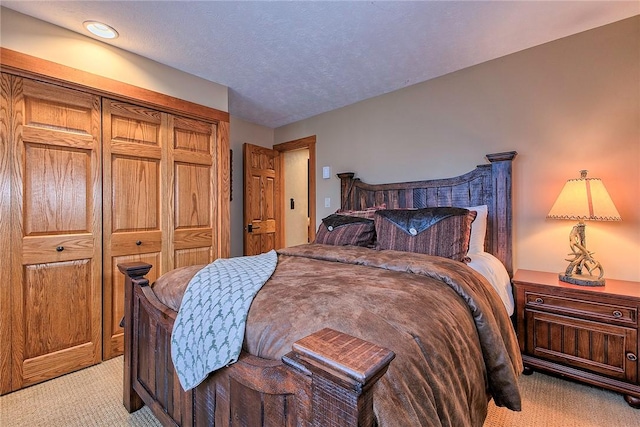 bedroom with light carpet and a textured ceiling