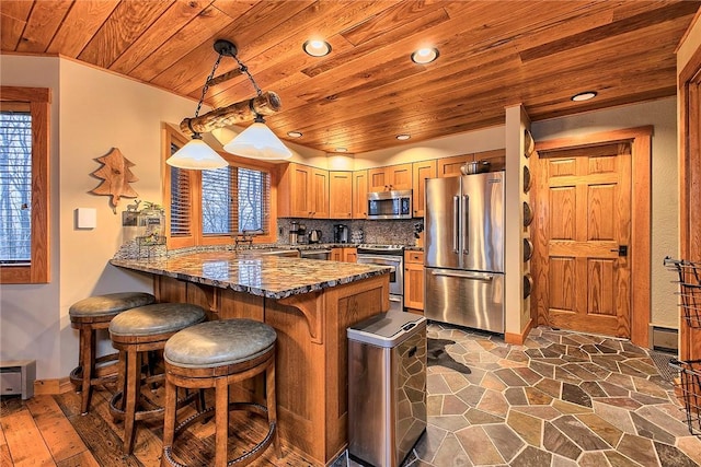 kitchen with appliances with stainless steel finishes, pendant lighting, wooden ceiling, and kitchen peninsula