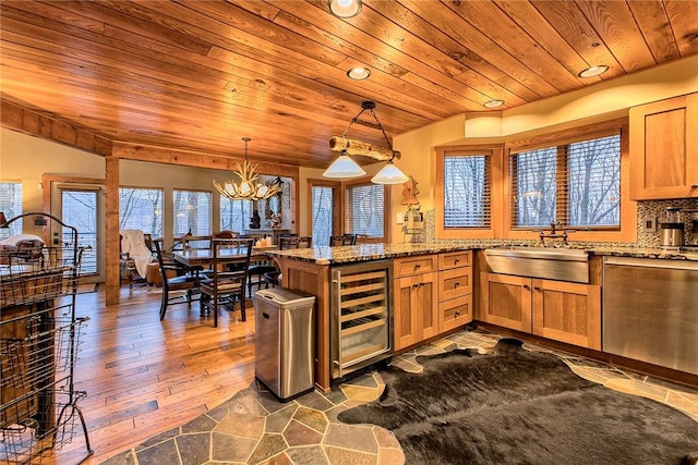 kitchen featuring sink, wood ceiling, hanging light fixtures, kitchen peninsula, and beverage cooler