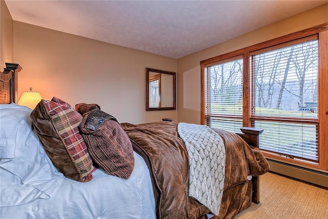 bedroom with a baseboard heating unit and a textured ceiling