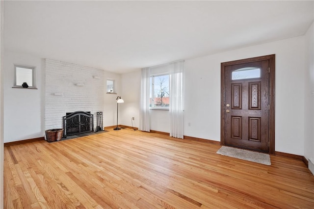 unfurnished living room featuring a fireplace and light hardwood / wood-style floors