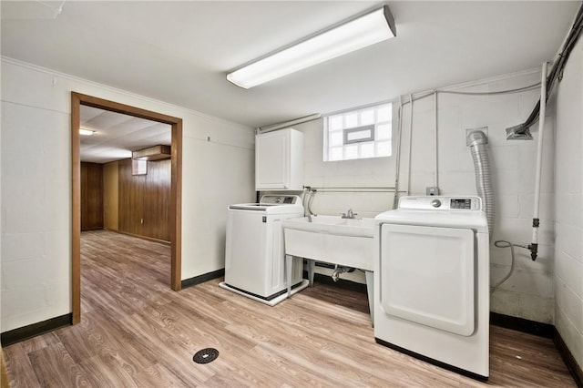 washroom with cabinets, sink, washer and dryer, and light hardwood / wood-style flooring