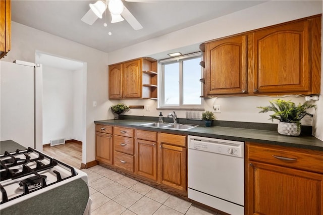 kitchen featuring light tile patterned flooring, white appliances, ceiling fan, and sink