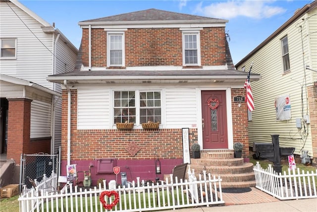 view of front of house with a fenced front yard and brick siding