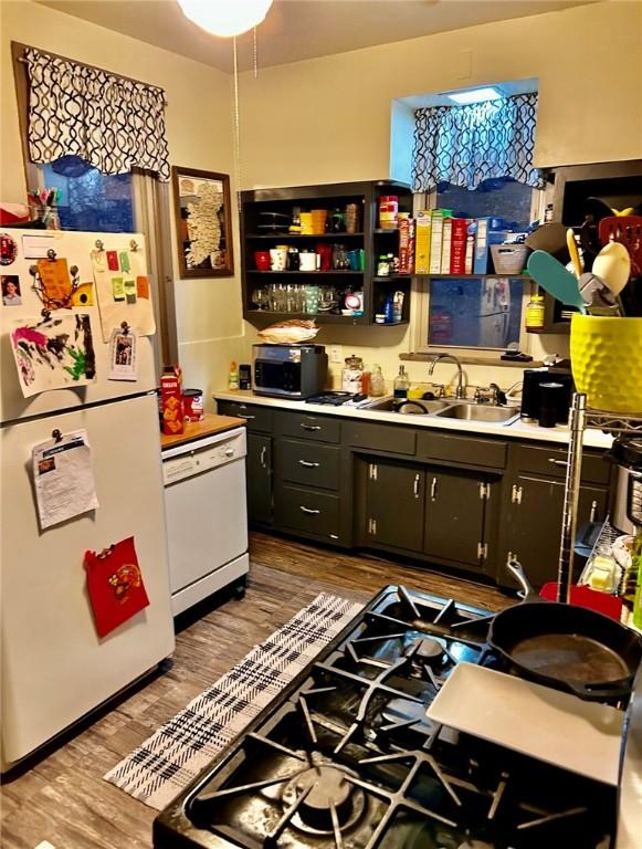 kitchen featuring white appliances, sink, and light hardwood / wood-style flooring