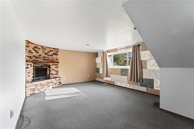 interior space featuring vaulted ceiling, carpet flooring, and a fireplace