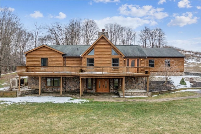 back of property featuring a deck and a lawn