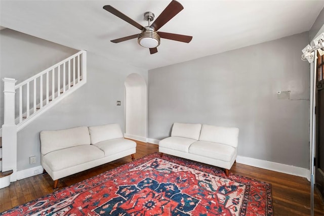 living room featuring dark wood-type flooring and ceiling fan