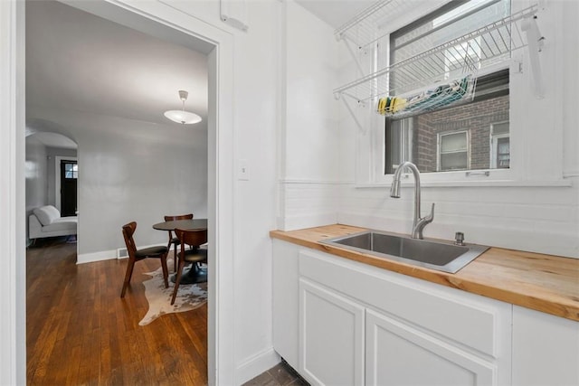 kitchen with white cabinetry, wooden counters, dark hardwood / wood-style flooring, and sink