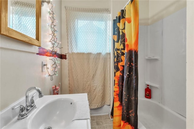 bathroom with shower / bathtub combination with curtain and sink