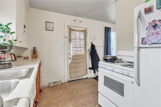 kitchen with white appliances and white cabinets