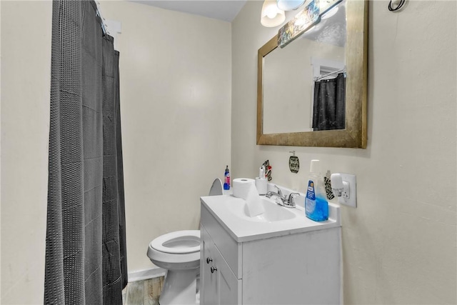 bathroom featuring vanity, hardwood / wood-style floors, curtained shower, and toilet