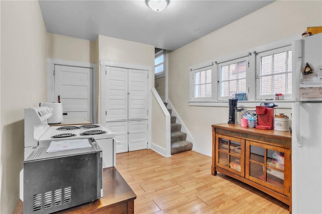 kitchen featuring light hardwood / wood-style flooring and white fridge