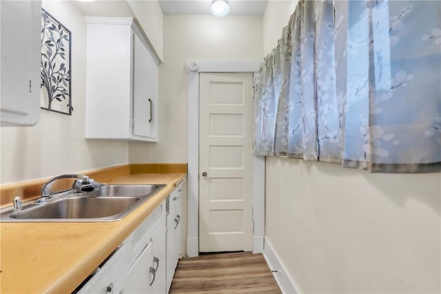 kitchen with white cabinetry, light hardwood / wood-style floors, and sink