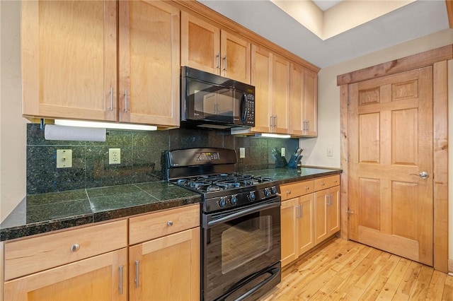 kitchen with backsplash, light brown cabinetry, light hardwood / wood-style flooring, and black appliances