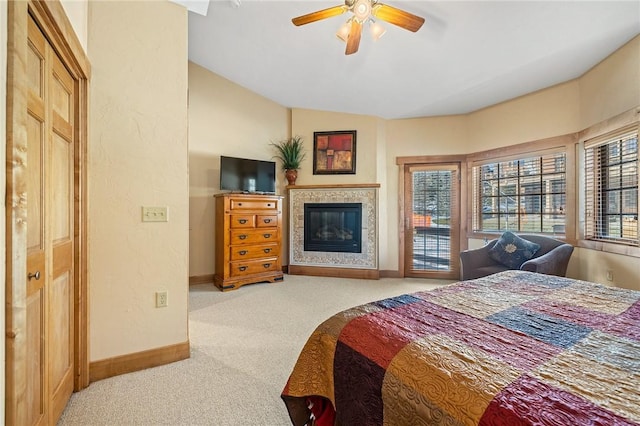 carpeted bedroom featuring ceiling fan, lofted ceiling, a tiled fireplace, and access to outside