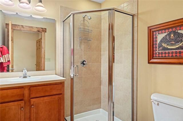 bathroom featuring vanity, an enclosed shower, and toilet