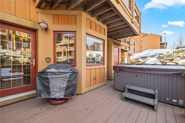 wooden deck featuring area for grilling and a hot tub