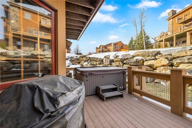 wooden terrace featuring a hot tub and area for grilling