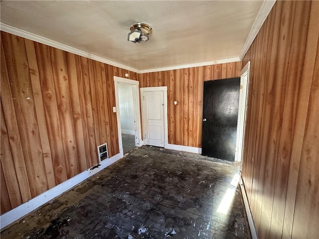 unfurnished room with crown molding and wooden walls