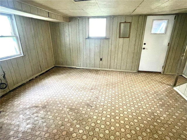 basement featuring wood walls and baseboards