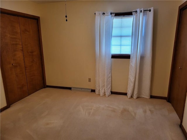 unfurnished bedroom featuring light carpet and a closet