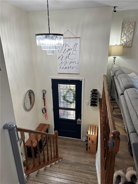 entrance foyer with hardwood / wood-style flooring, a chandelier, and a high ceiling