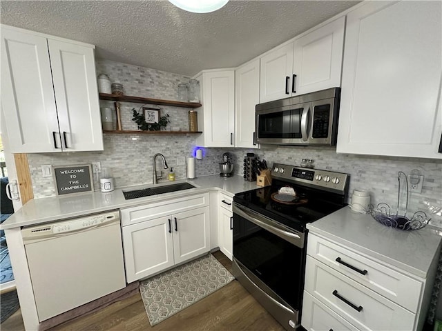 kitchen with white cabinetry, sink, dark hardwood / wood-style flooring, and appliances with stainless steel finishes