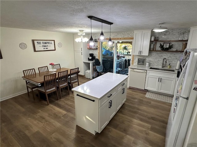 kitchen with white cabinetry, white appliances, sink, and pendant lighting