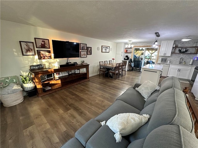 living room with dark hardwood / wood-style flooring, sink, and a textured ceiling