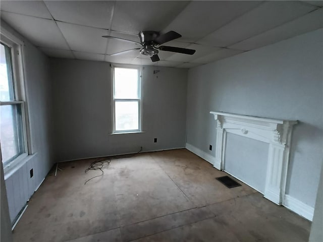 empty room with a drop ceiling and ceiling fan