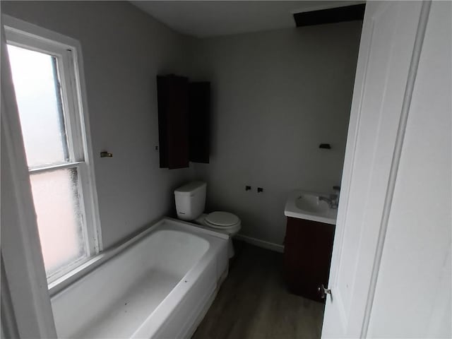 bathroom featuring vanity, toilet, hardwood / wood-style floors, and a bath