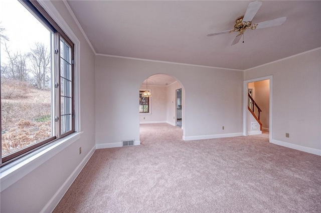 carpeted spare room with crown molding and ceiling fan